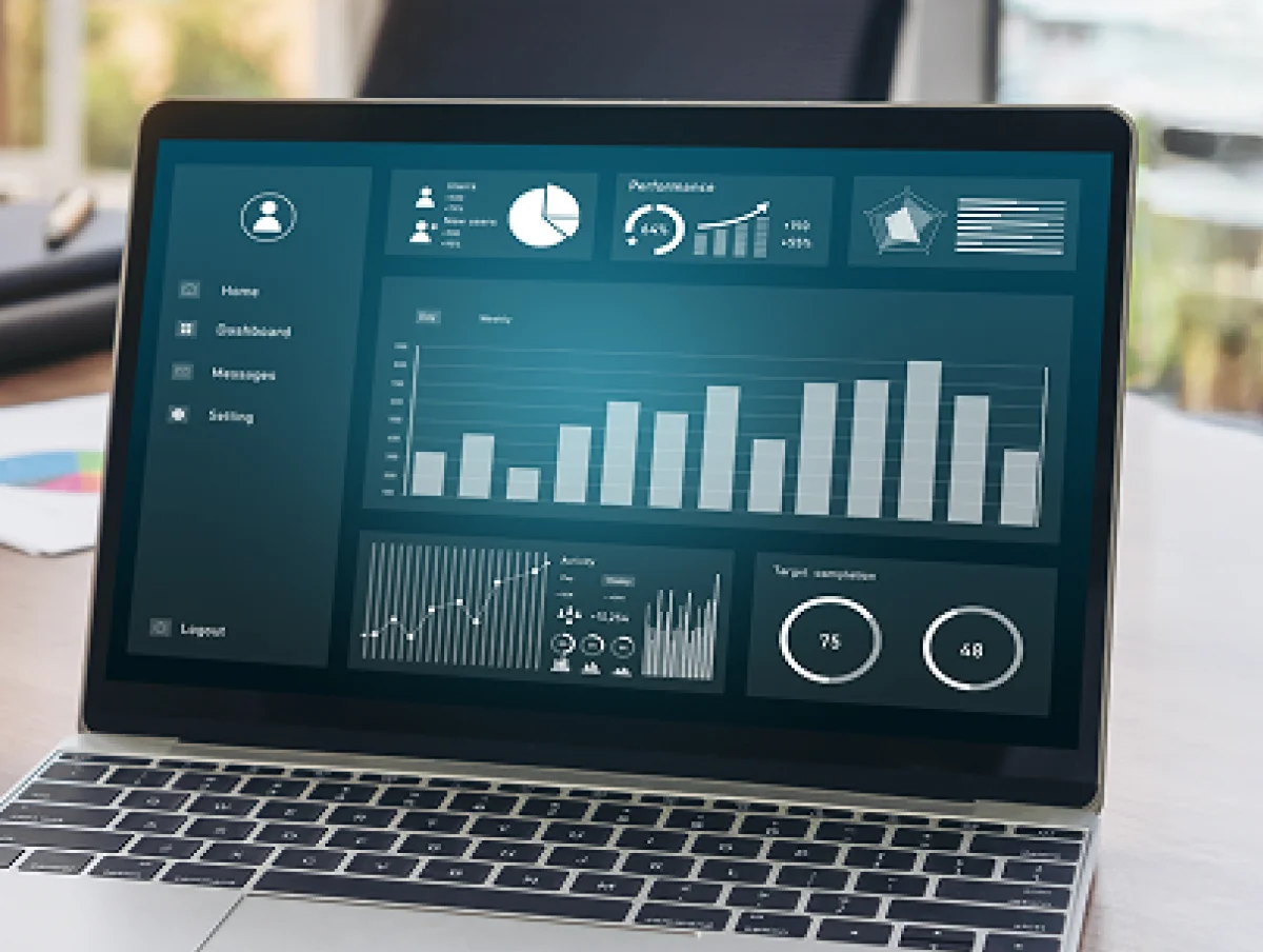 Laptop showing data analytics dashboard with bar charts, line graphs, and circular chart
