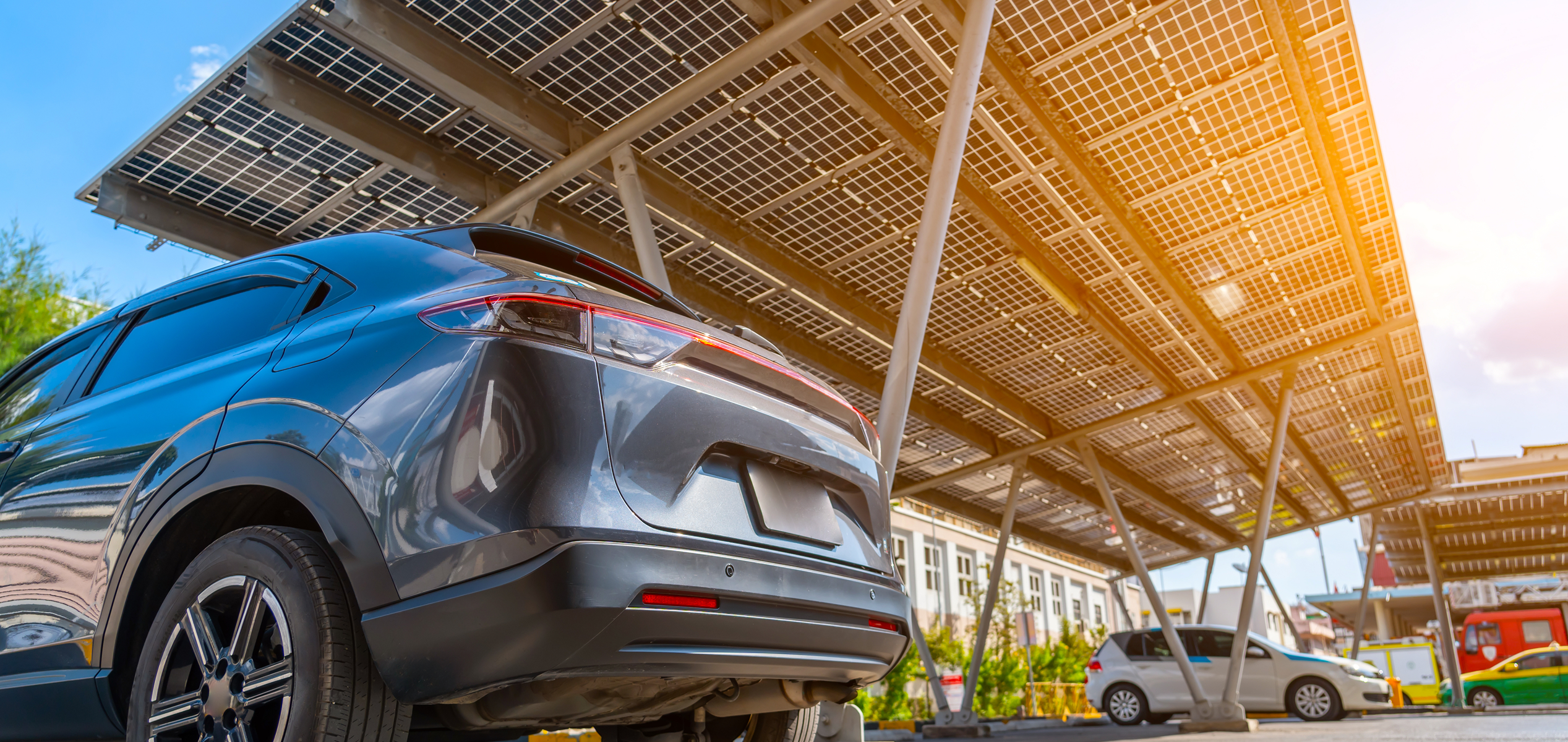 Solar carport with cars parked underneath, generating clean electricity
