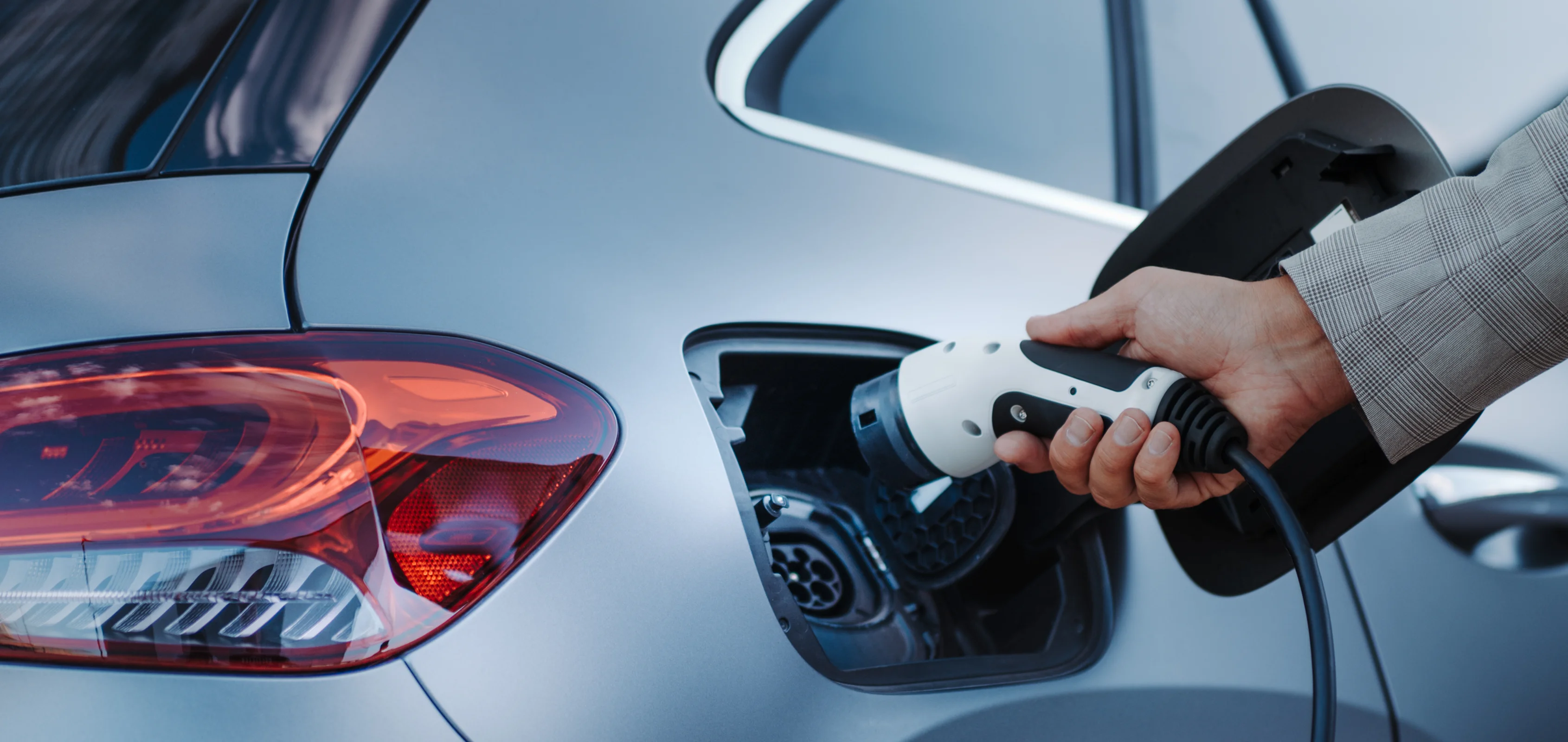 EV charging in progress with cable being plugged into the vehicle