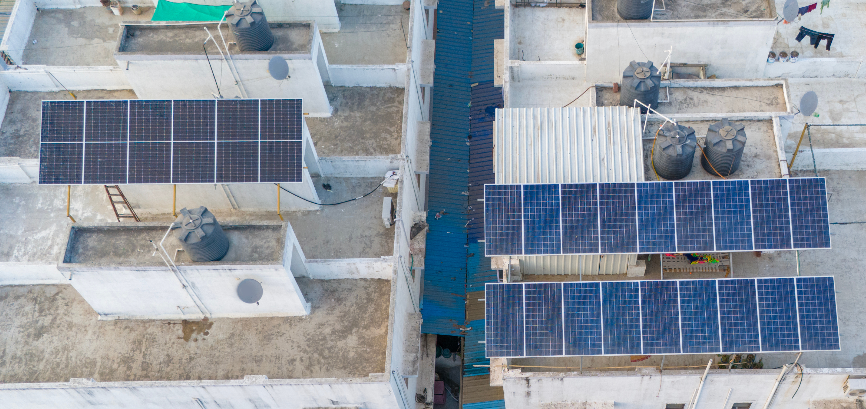 An aerial view of solar panels installed on the rooftops of buildings